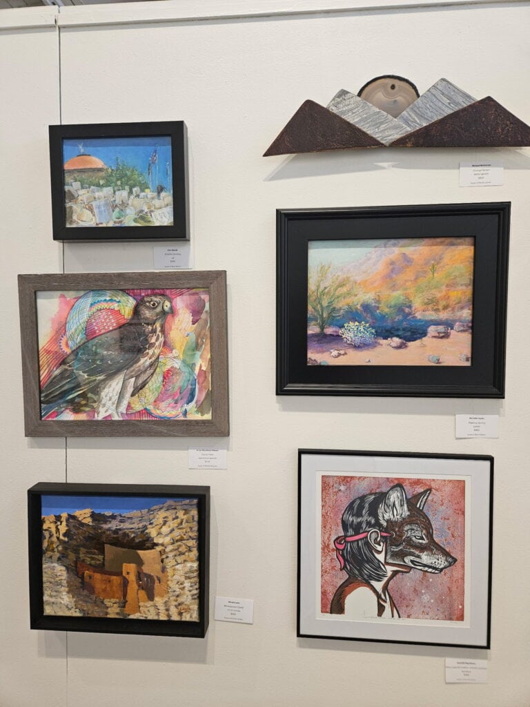 Six pieces of art hanging on a gallery wall