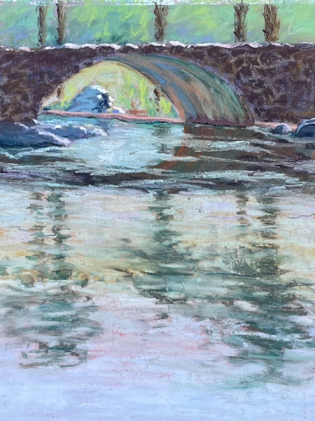 Reflections of palm trees in the water under a stone bridge